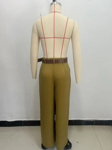 Dettaglio di pantaloni larghi a vita alta giallo senape con cintura in pelle marrone