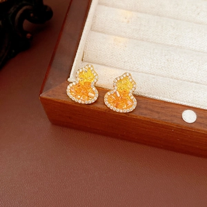 Vue macro de boucles d'oreilles gourde plaquées or 18K avec pierres jaunes et cristaux