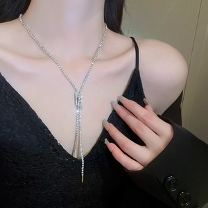 Detailed view of a silver zipper style Y-necklace with tassels and sparkling cubic zirconia