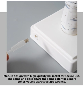 Detailed close-up of the square white base featuring the DC power port and charging cable