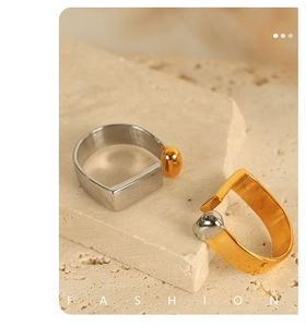Detailed close-up of two-tone silver and gold adjustable rings on a textured stone base