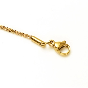 Detailed close-up of golden lobster clasp and textured chain link on stainless steel anklet