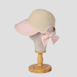 Women's summer straw sun hat with pink brim and large decorative bow on the back