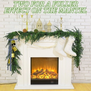 Close-up of artificial Norfolk pine garland with gold bells and festive ribbons on a mantel