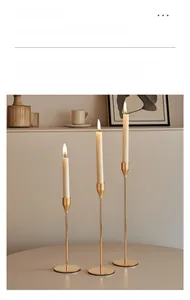 Detailed view of three-piece gold metal candle holders in staggered heights on a table