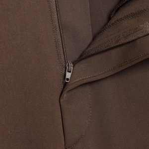 Dettaglio dei pantaloni marroni stile inglese con cerniera e trama del tessuto