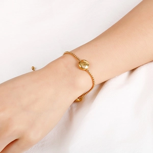 Detail of a gold zodiac pendant bracelet on wrist with adjustable sliding clasp