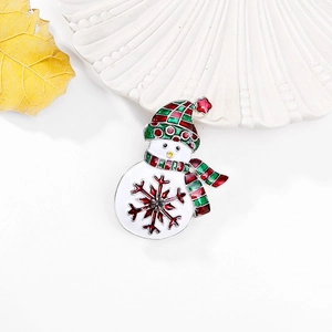 Close-up of enamel snowman brooch with red scarf and sparkling crystal center