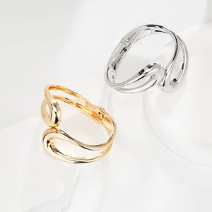 Detail of irregular minimalist gold and silver bangles on white stone for women
