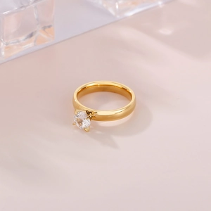 Macro view of 4mm round cubic zirconia in a four-claw setting on gold stainless steel ring