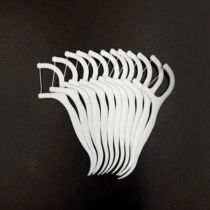 Portable white dental floss picks arranged on black background for oral hygiene care