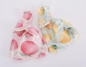 Detailed view of velvet wrist bags with peach and lemon prints on pink and blue fabrics