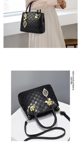 Détail d'un sac à main noir gaufré à damier avec pendentif feuille dorée et perles