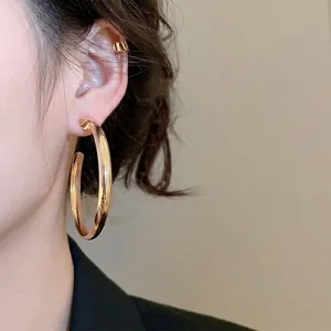 Polished gold geometric hoop earrings with a minimalist large circular design for women