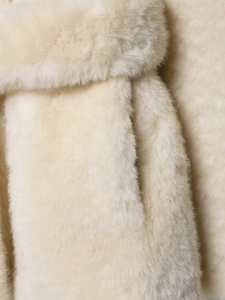 Detailansicht der weichen Textur und Taschennaht des modischen Kunstpelzmantels