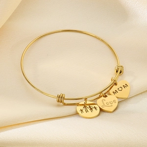 Detail of adjustable gold wire bracelet with MOM, Love heart and family silhouette charms