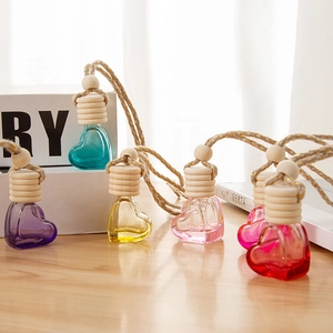 Heart-shaped glass diffuser bottles with wooden caps and colorful liquids in various shades