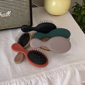 Mini spazzole per capelli portatili in vari colori su tessuto bianco decorativo