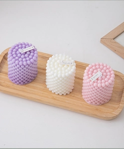 Detailed top view of geometric pillar scented candles in purple, white and pink colors