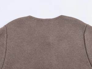 Detail of crew neckline and fine knit texture on a tan brown button-up cardigan