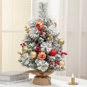 Mini desktop Christmas tree with fake snow, red and gold ornaments, and burlap base