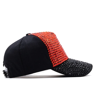 Detail of sparkly orange and black rhinestones on a stylish baseball cap with side view
