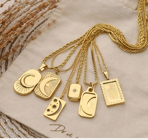 Detailed view of gold plated celestial pendants with moon and sun motifs on canvas