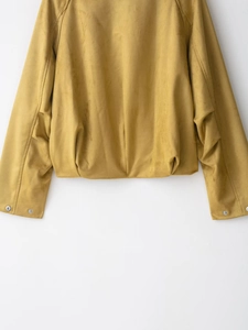 Detail of ginger yellow suede bomber jacket showing elastic hem and metal snap button cuffs