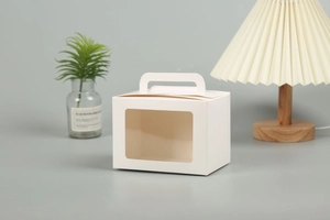 Close-up of a white paper gift box with a transparent window and portable handle