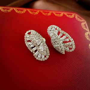 Macro shot of silver butterfly stud earrings with sparkling cubic zirconia on red texture