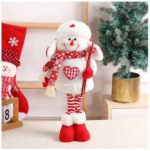 Close-up of a Christmas snowman plush doll with a red star hat on a cozy white blanket