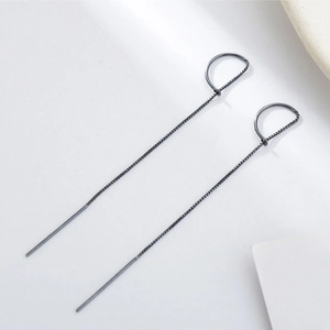 Detail of gunmetal long chain tassel earrings with minimalist metal hook and needle design