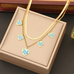Double-layered gold necklace featuring snake chain and heart-shaped evil eye pendants