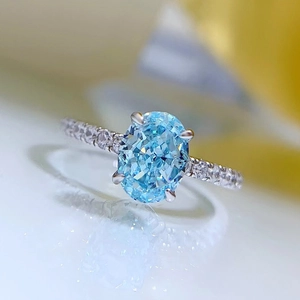 Macro shot of oval light blue gemstone ring with pave diamonds on silver band