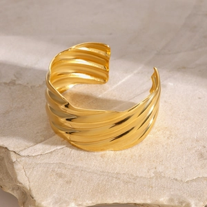 Minimalist 18k gold plated stainless steel wavy cuff bracelet on natural stone