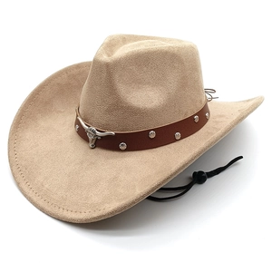 Détail d'un chapeau de cowboy en daim avec emblème de tête de taureau en argent et clous