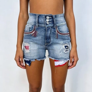 Détail de mini-short en jean taille haute avec patchs drapeau et ourlets effilochés