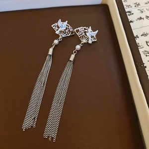 Detail of silver long tassel earrings with hollow fan motif and white crane pattern
