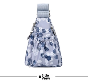Side view of multi-pocket nylon crossbody bag with blue polka dot patterns