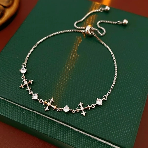 Detailed shot of silver cross bracelet with white zircon on a dark jewelry box