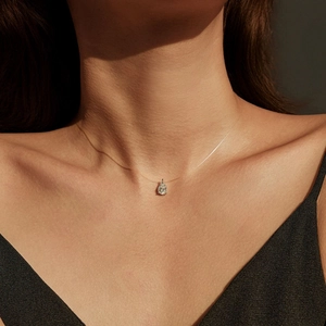 Elegant pear-cut moissanite pendant on a clear invisible fishing line necklace for women