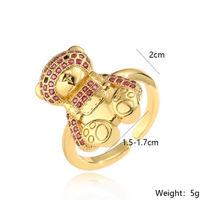 Macro detail of a 18K gold-plated bear ring with red zircon on a white background