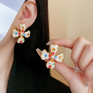 Detailed shot of vintage gold clover earrings with colorful rhinestones and faux pearls