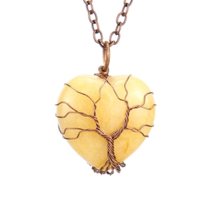 Macro detail of handmade wire-wrapped tree of life on heart-shaped natural crystal