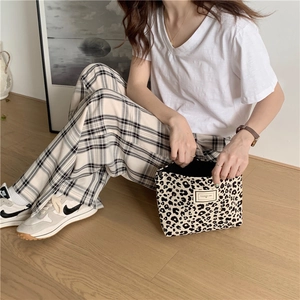 Detail showing leopard print canvas storage bag held by a model in a casual setting