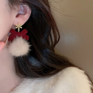 Detail of Christmas bow earrings with gold snowflake, red velvet, and white plush pompom
