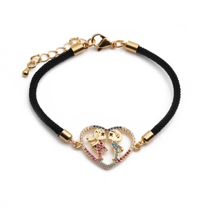 Detail of adjustable heart bracelet with boy and girl charms in gold and zircon