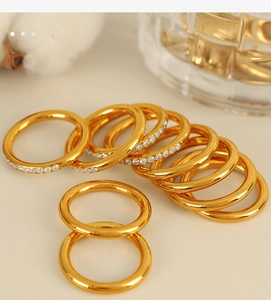 Close-up of elegant gold stacked rings with minimalist bands and sparkling crystal accents
