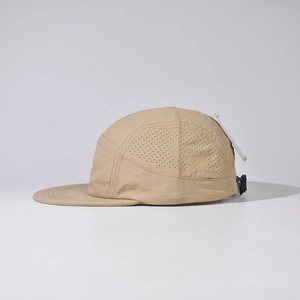 Vue latérale d'une casquette beige à 5 panneaux avec aérations découpées au laser.