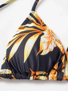 Detailed view of halter triangle bikini top with tropical leaf print and textured fabric